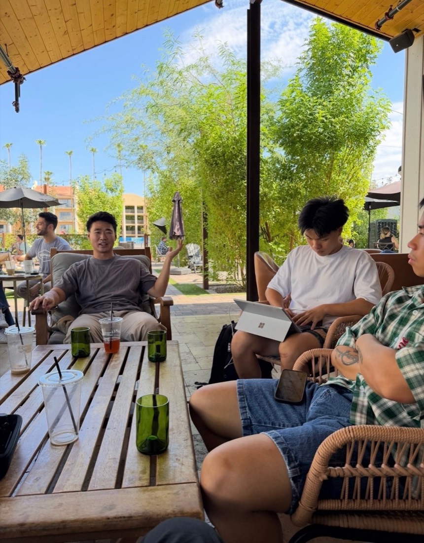 Builders talking on a bench under a pergola on a bright afternoon