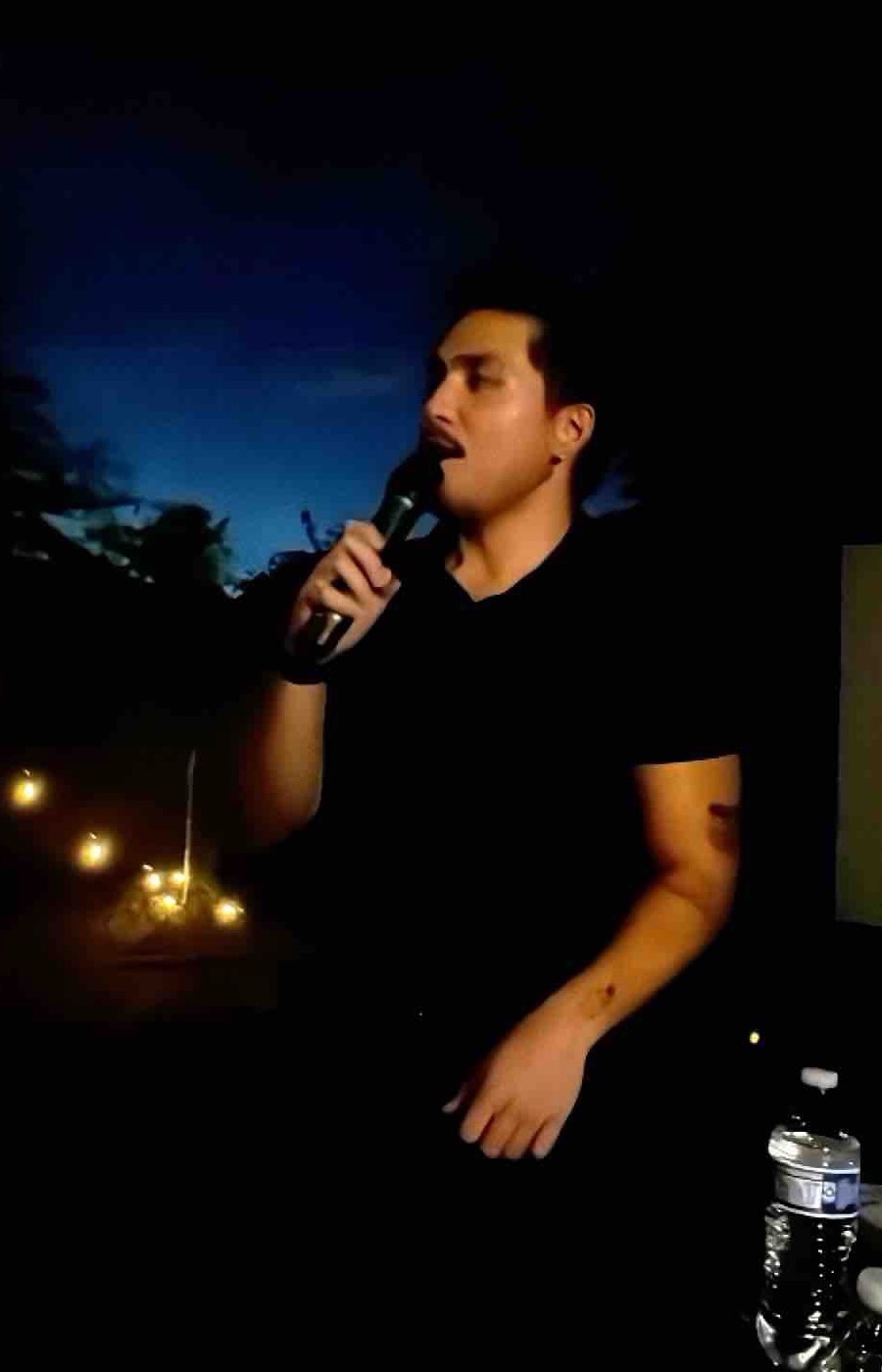 A founder speaking into a microphone after dark at the Founder Dinner